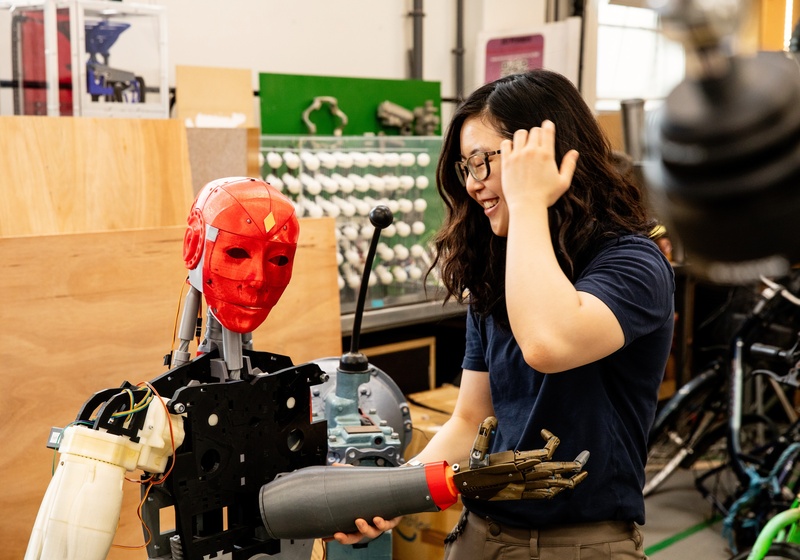 Woman in a lab looking at a robot